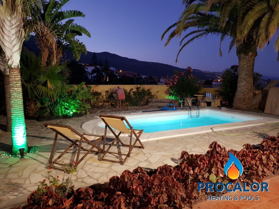 Compact pool with palm trees and lighting at sunset, installed by PROCALOR
