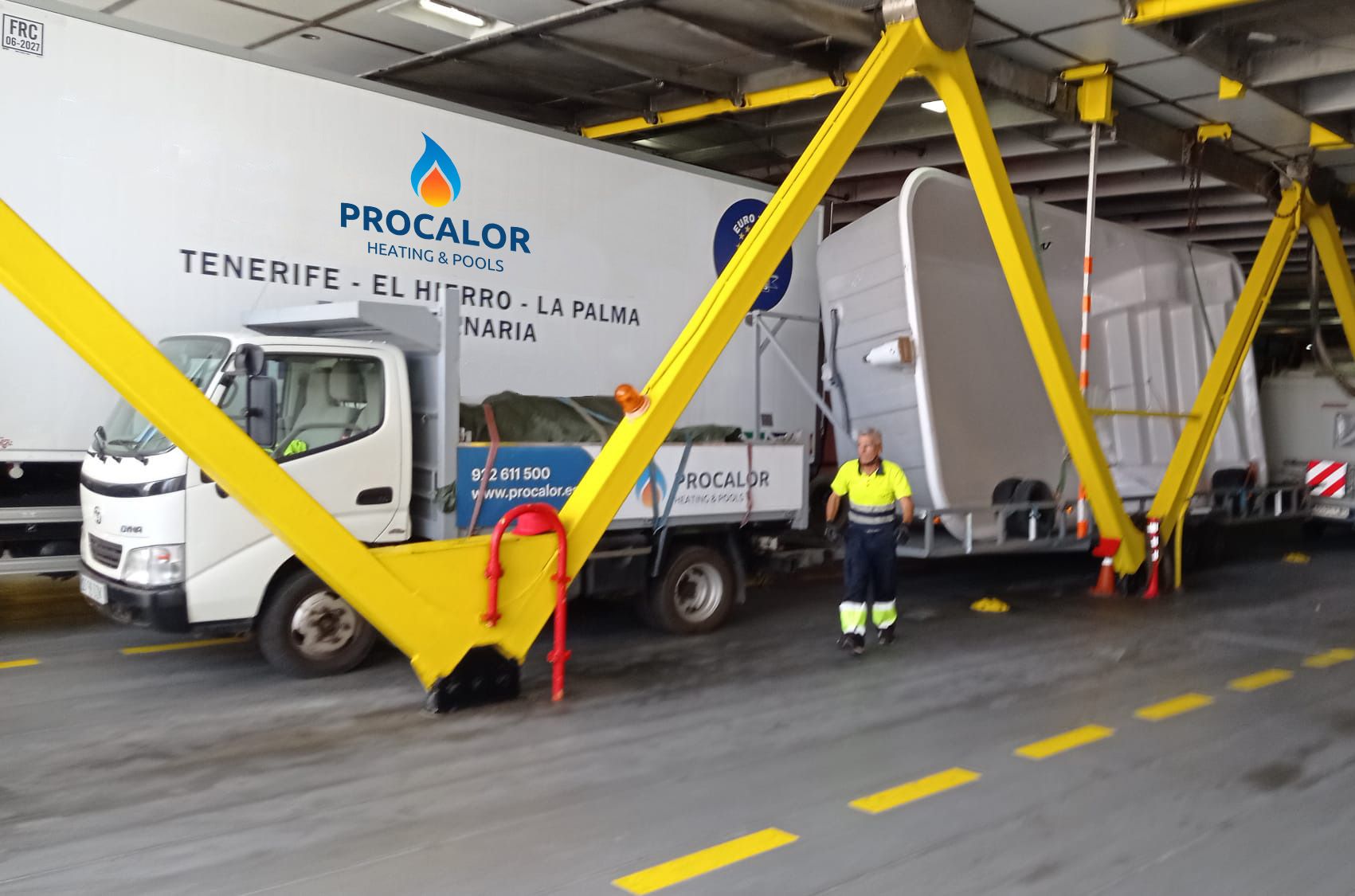 PROCALOR truck carrying a compact pool on its trailer, inside a ferry bound for El Hierro, next to a worker